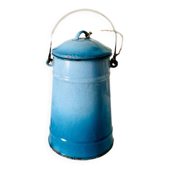 Old vintage milk jug in degraded blue enameled sheet metal