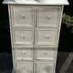 Small antique workshop cabinet with 8 painted wooden drawers.