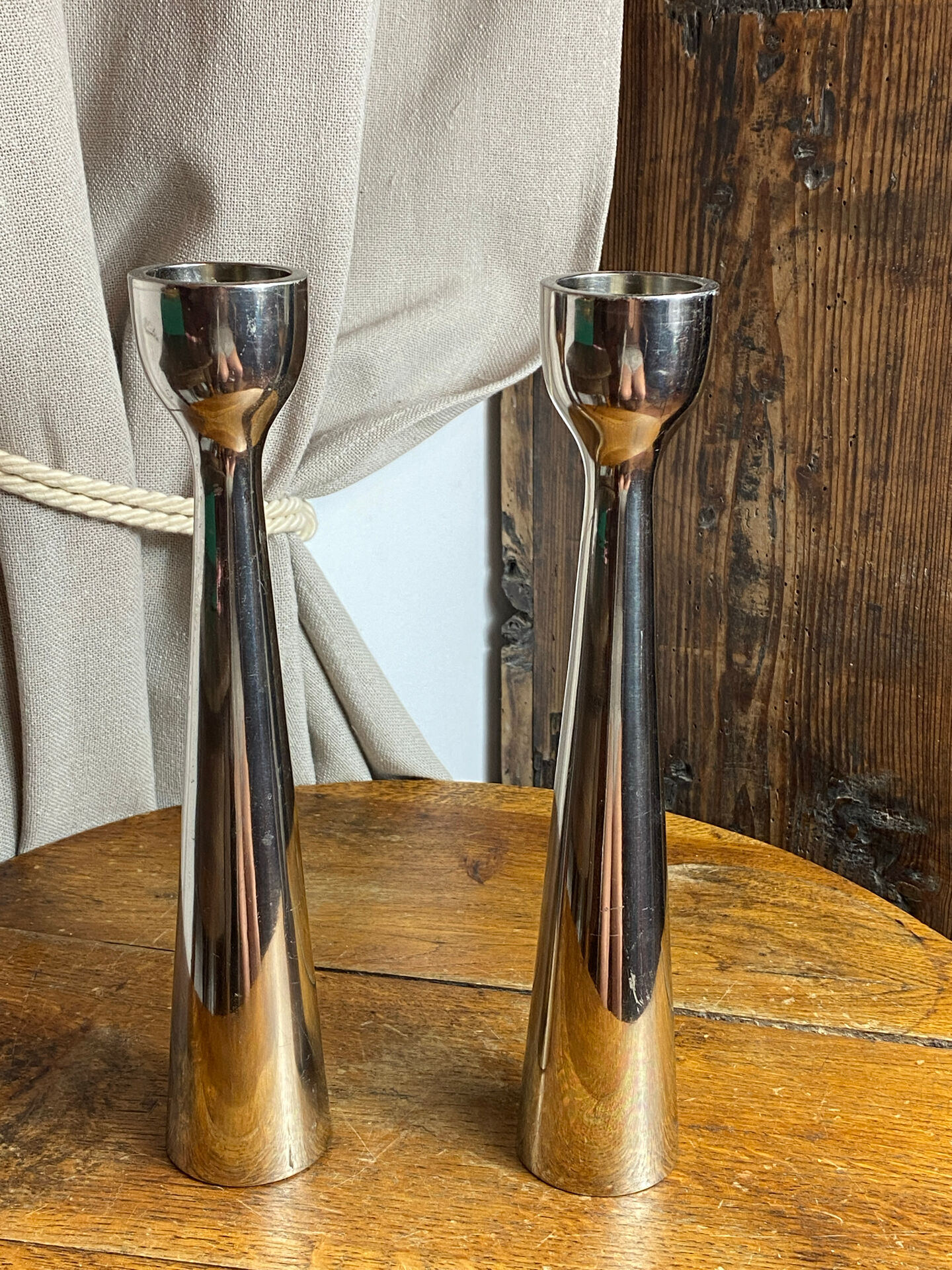 Pair of polished aluminium candlesticks