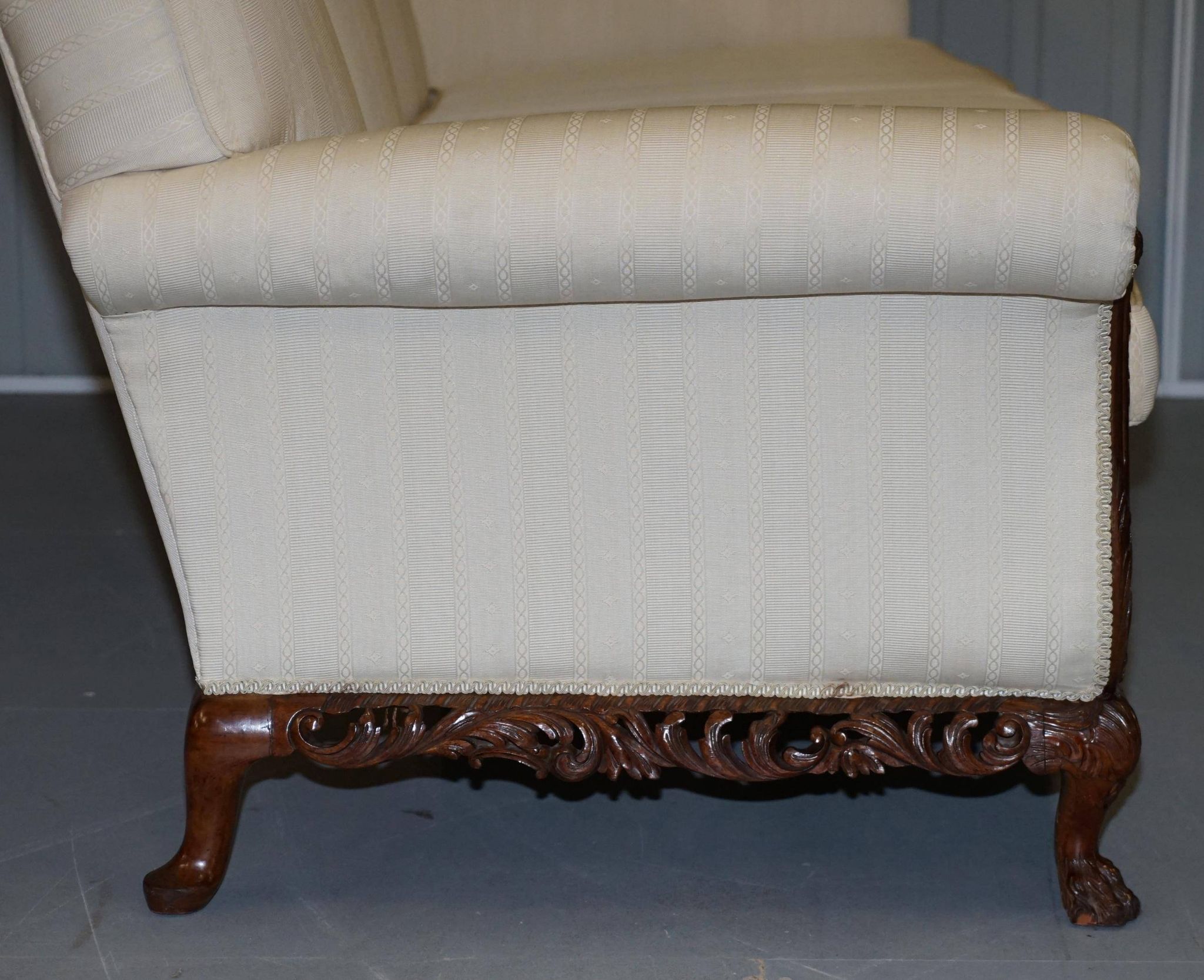 Three-seater canapé carved from solid walnut with claw feet.