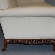 Three-seater canapé carved from solid walnut with claw feet.