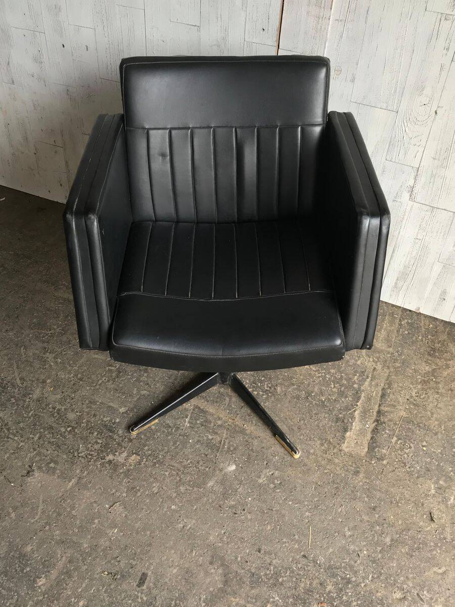 Black swivel club armchair in faux leather with golden metal base, Czechoslovakia 1960s.