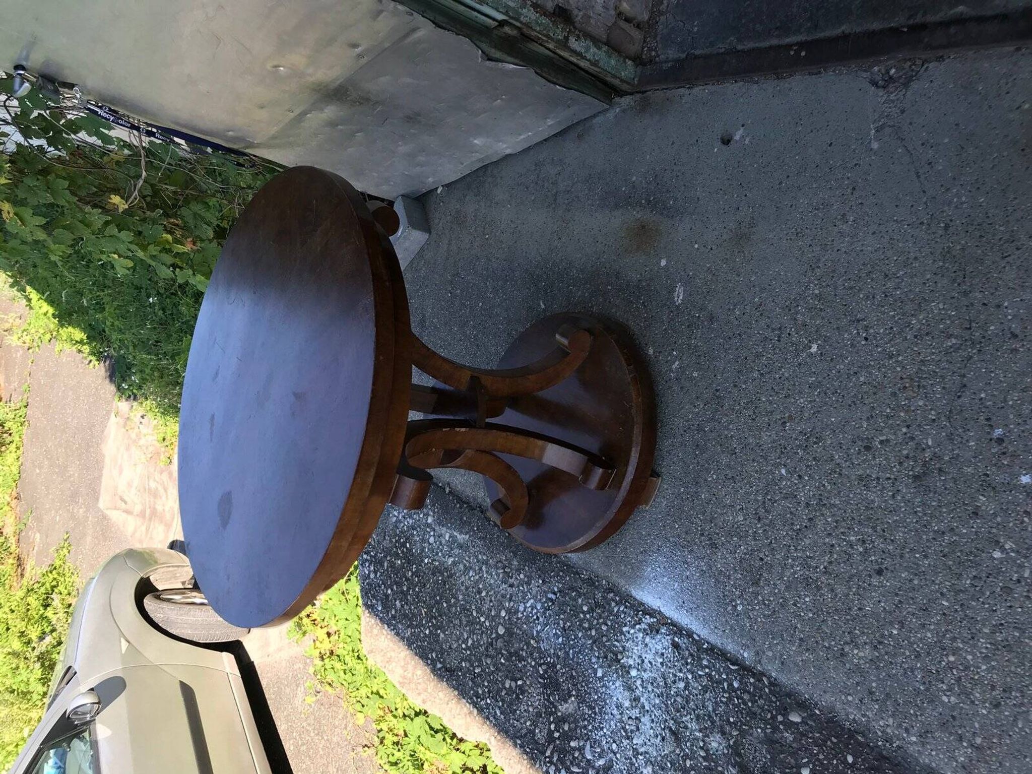Art Deco side table in brown walnut, round top and scroll legs, France 1930s.