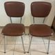 Two brown faux leather chairs.
