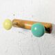Vintage wall coat rack with 2 yellow and green balls.