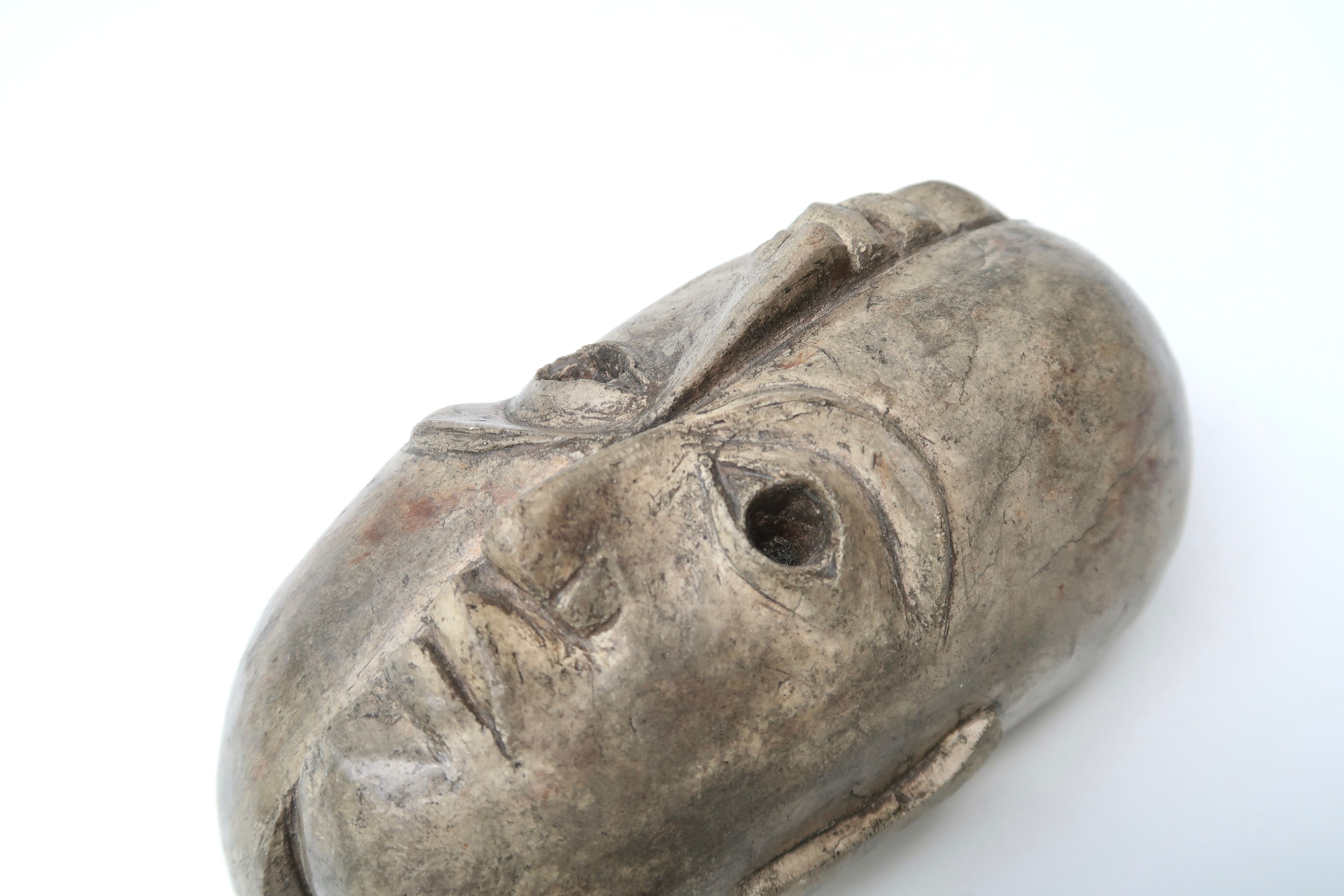 Patinated plaster sculpture paper press: Inverted faces