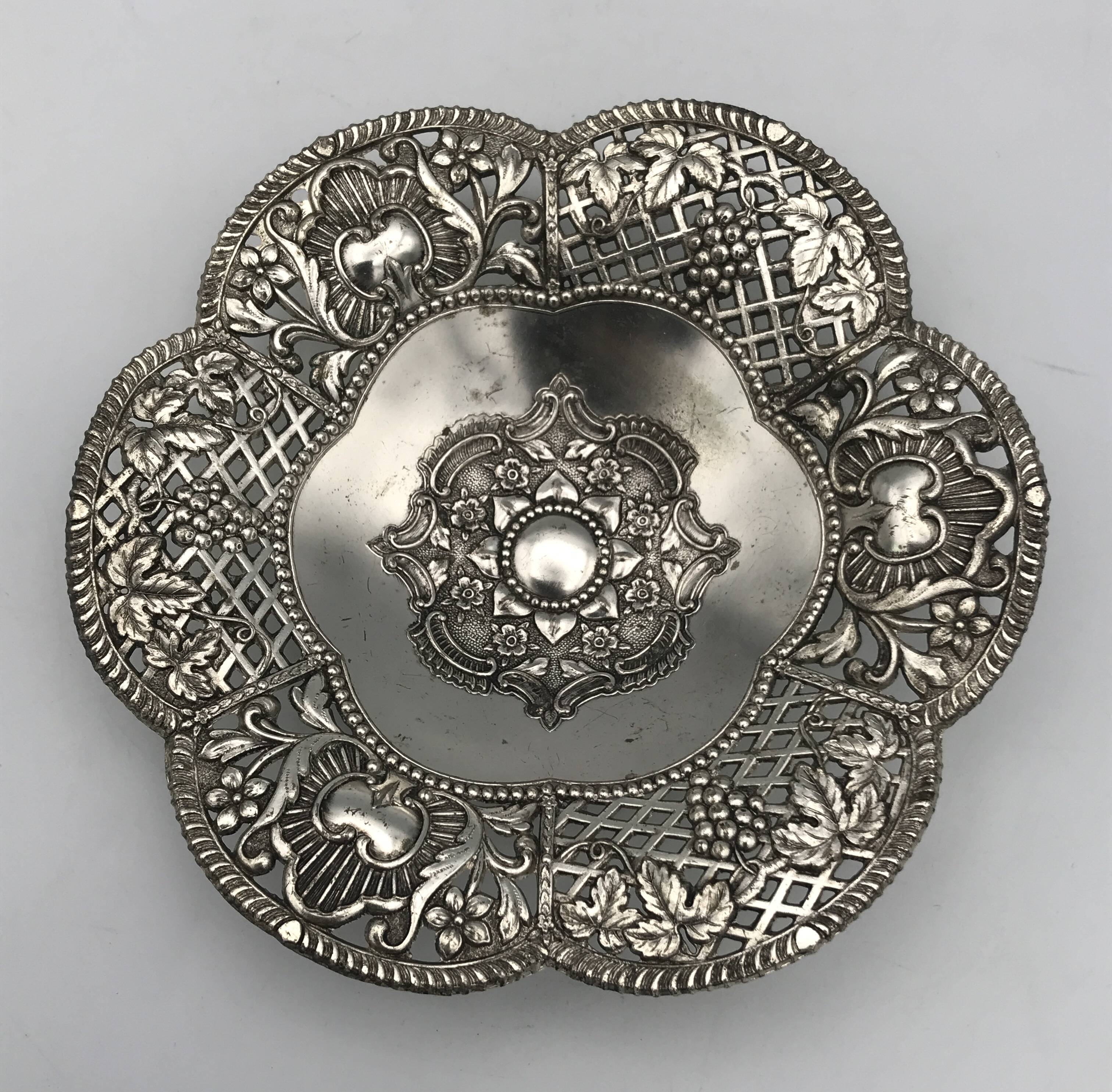 Silver-plated metal pocket emptier with openwork outline decoration