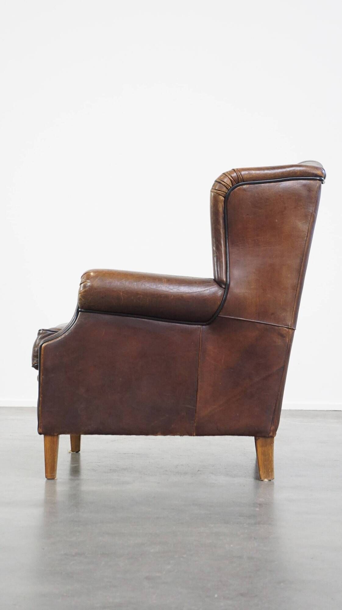 Wing chair made of sheepskin and neatly finished with black piping