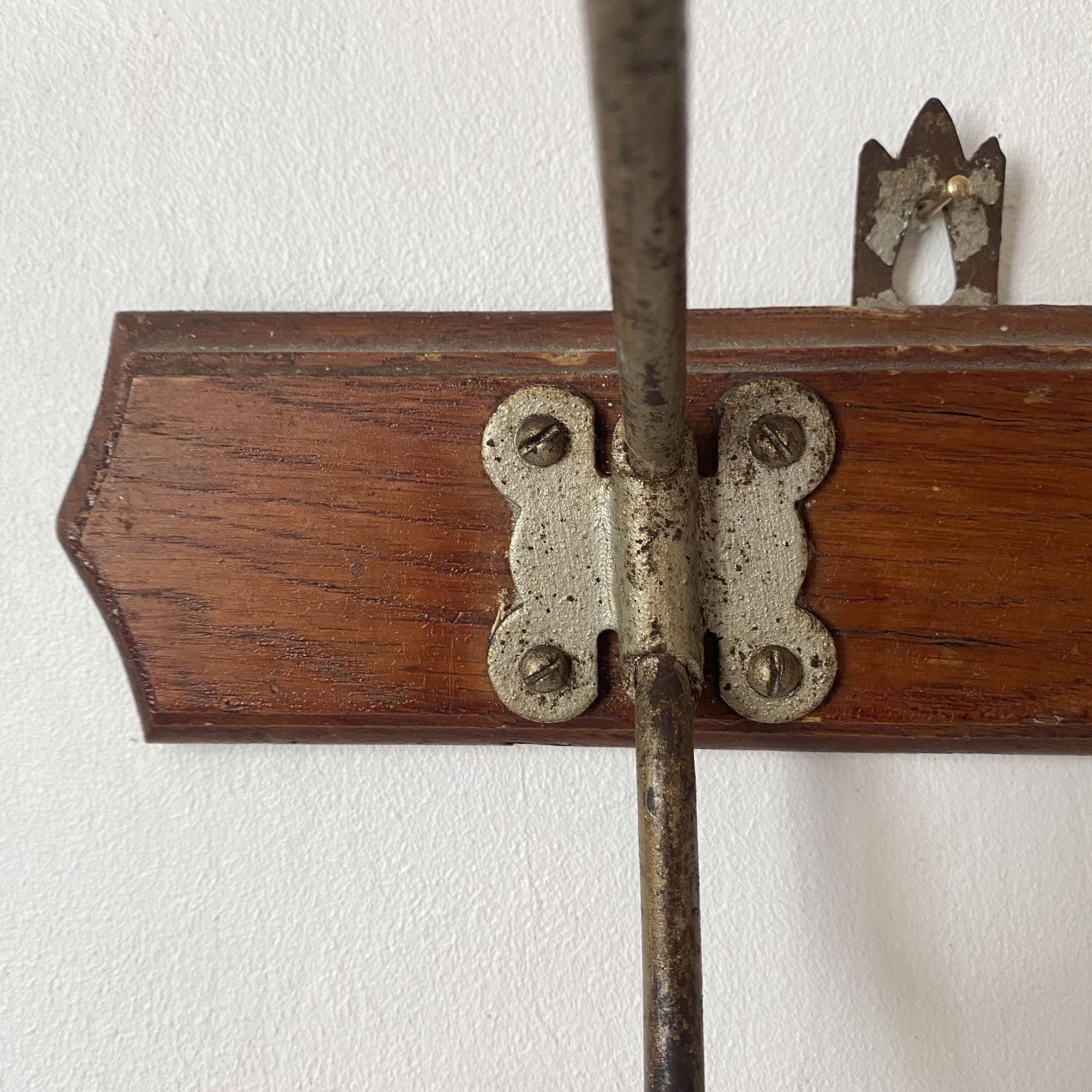 Old wooden and metal wall-mounted coat rack.