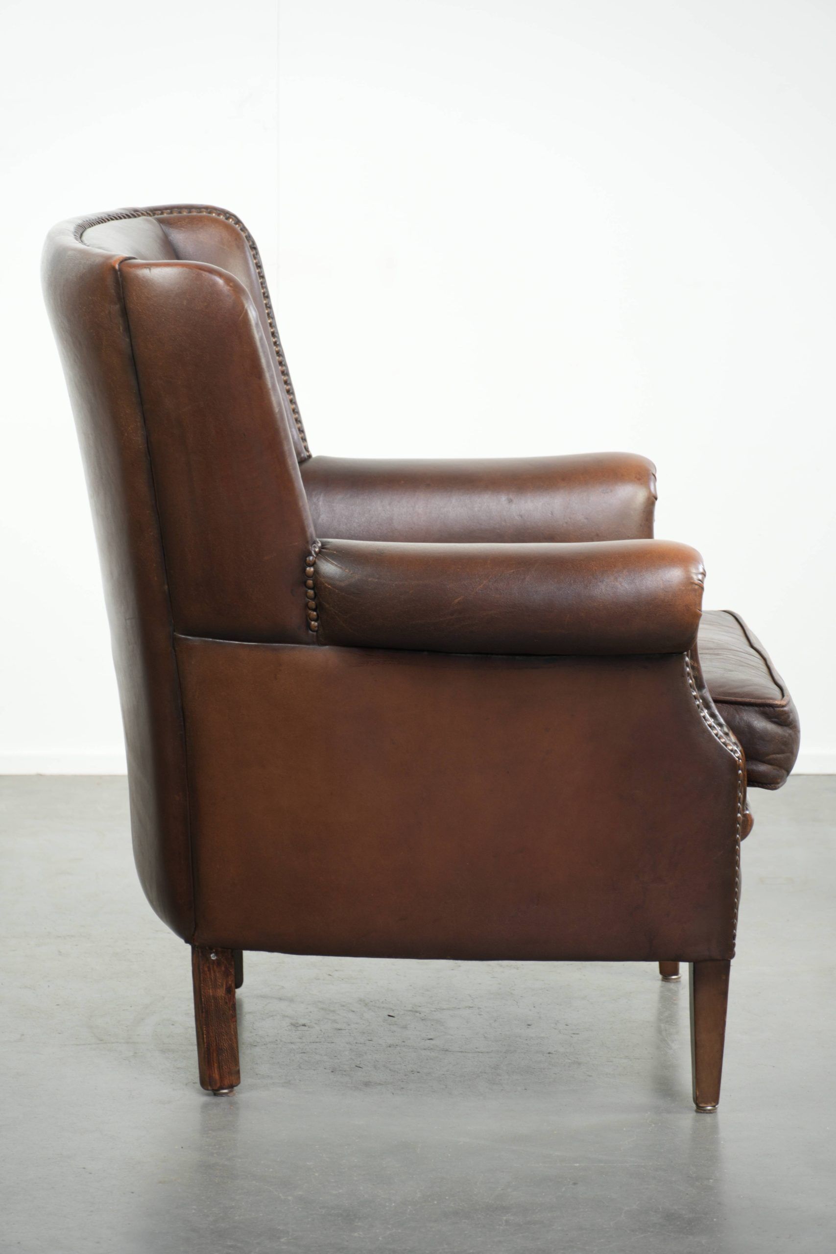 Subtle sheepskin wingback armchair with a deep cognac colour