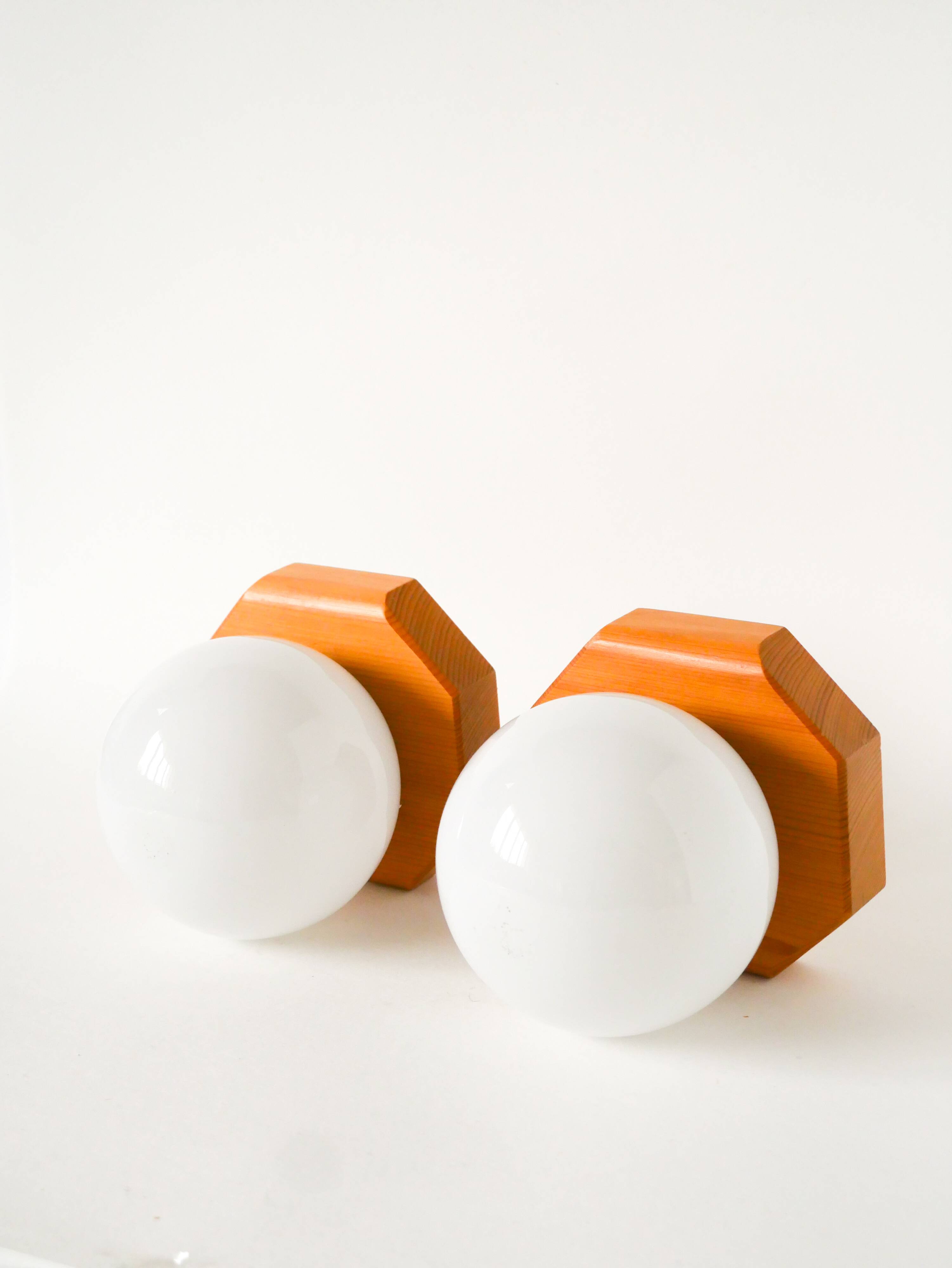 Pair of globe wall lights in opaline with a pine base, 1980.