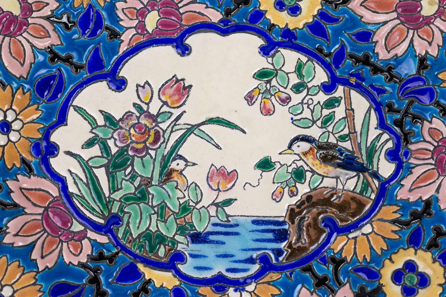 Assiette Longwy 1930 – Émaux à décor d’oiseaux et fleurs oranges