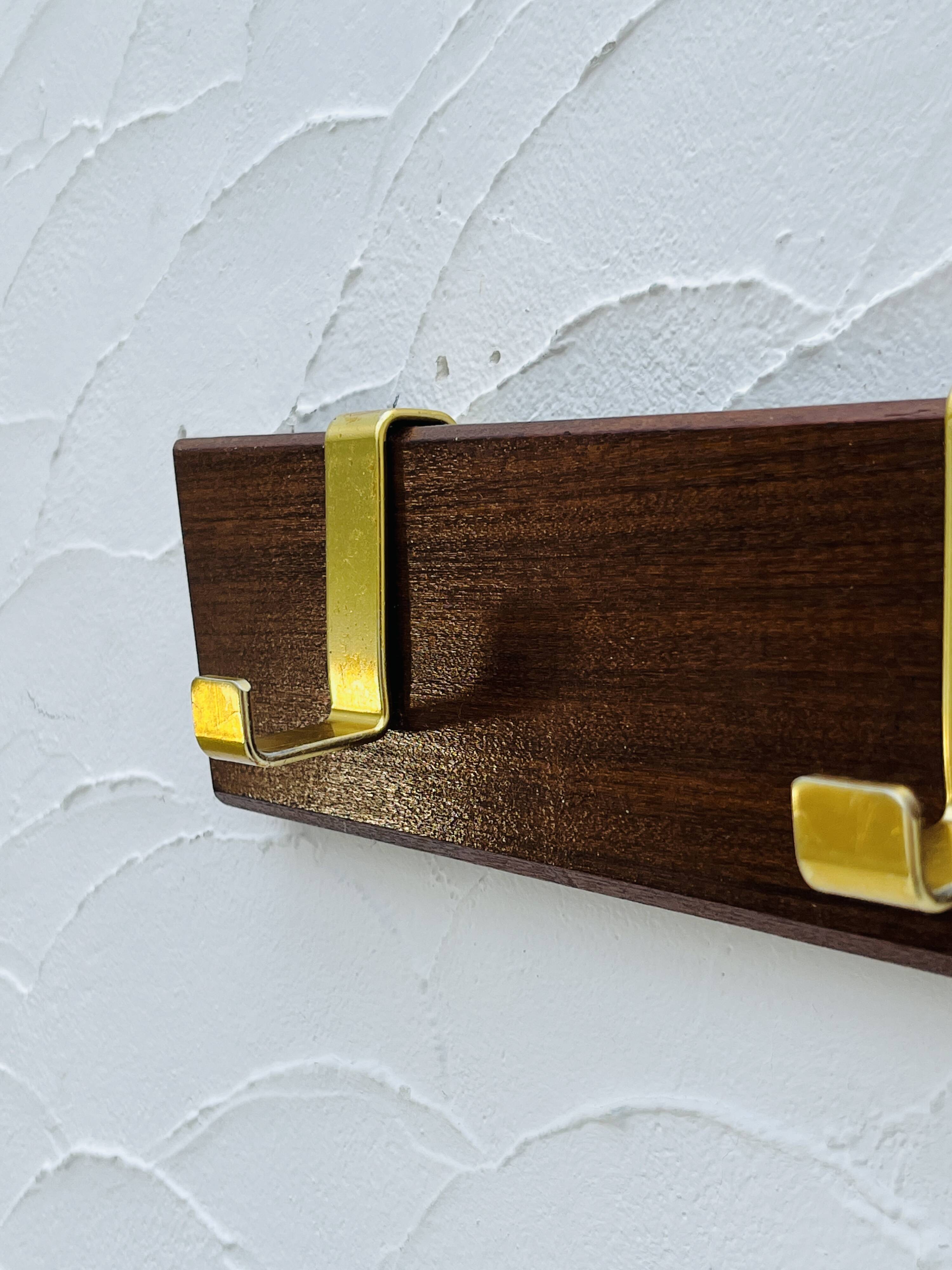 Vintage wooden and brass coat rack with 3 hooks from the 1960s.