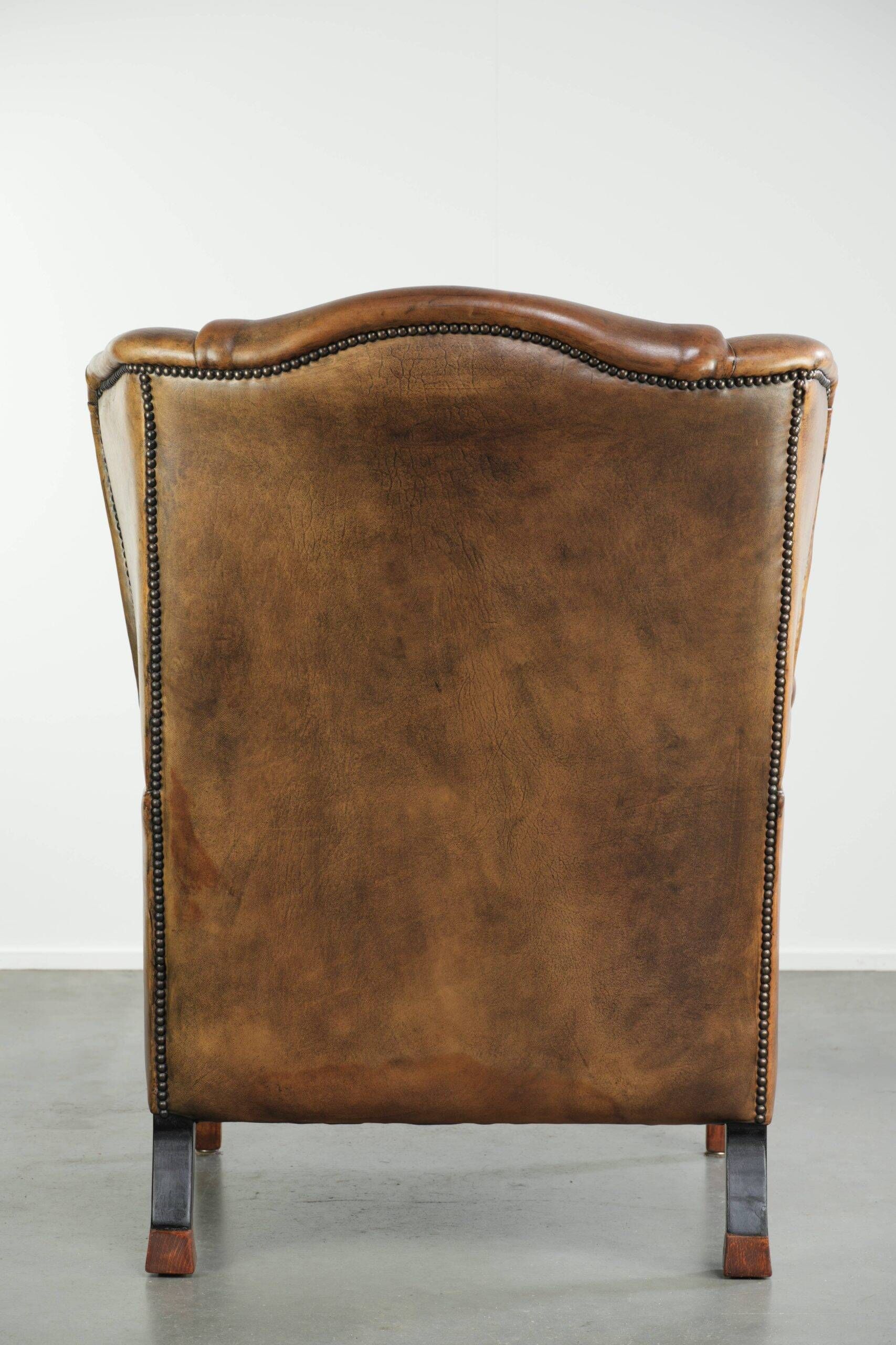 Sheepskin wingback armchair with patina finished with decorative nails