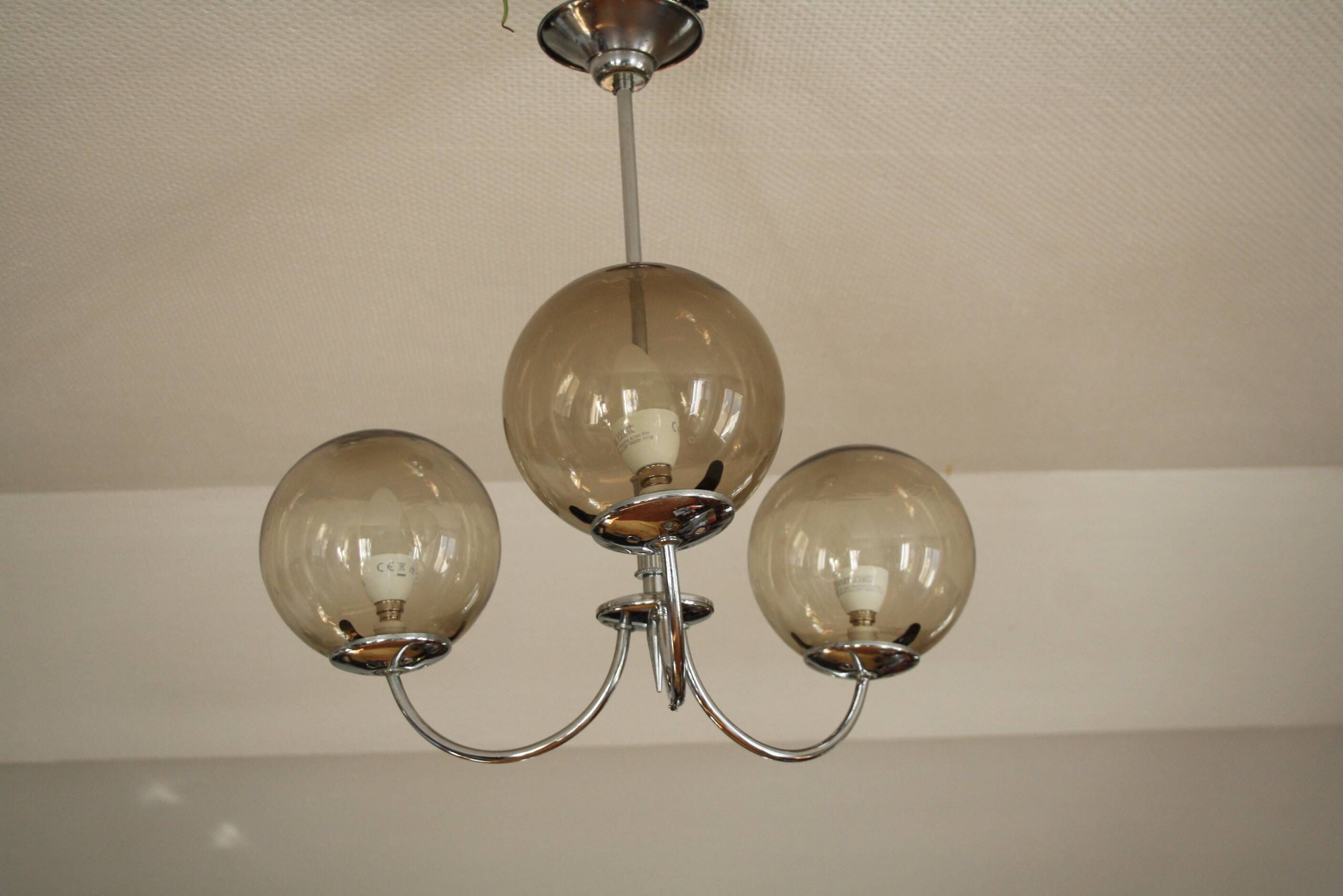 Chrome metal chandelier with smoked glass globes.