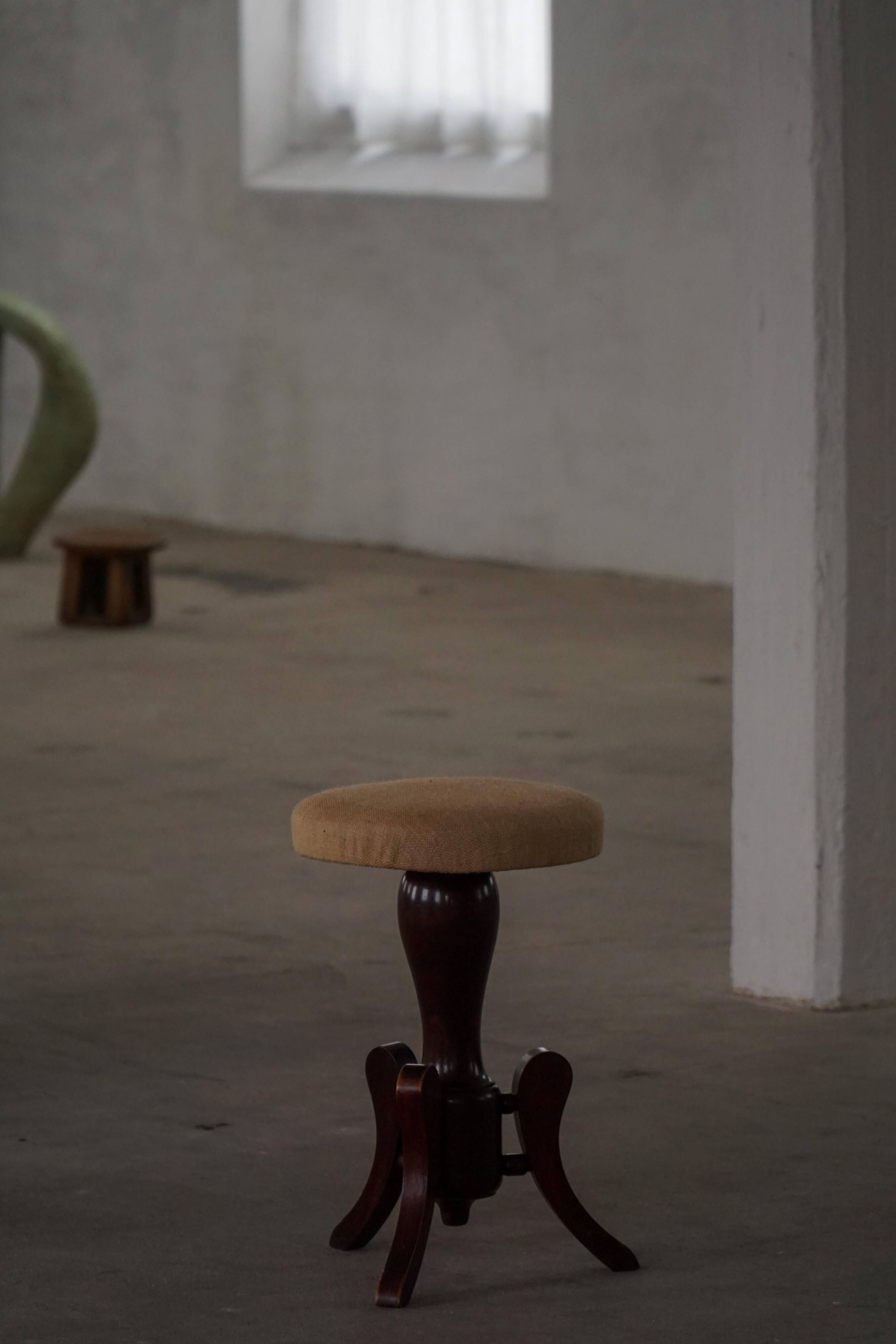 Adjustable Victorian-style piano stool with a jute fabric seat, early 20th century.