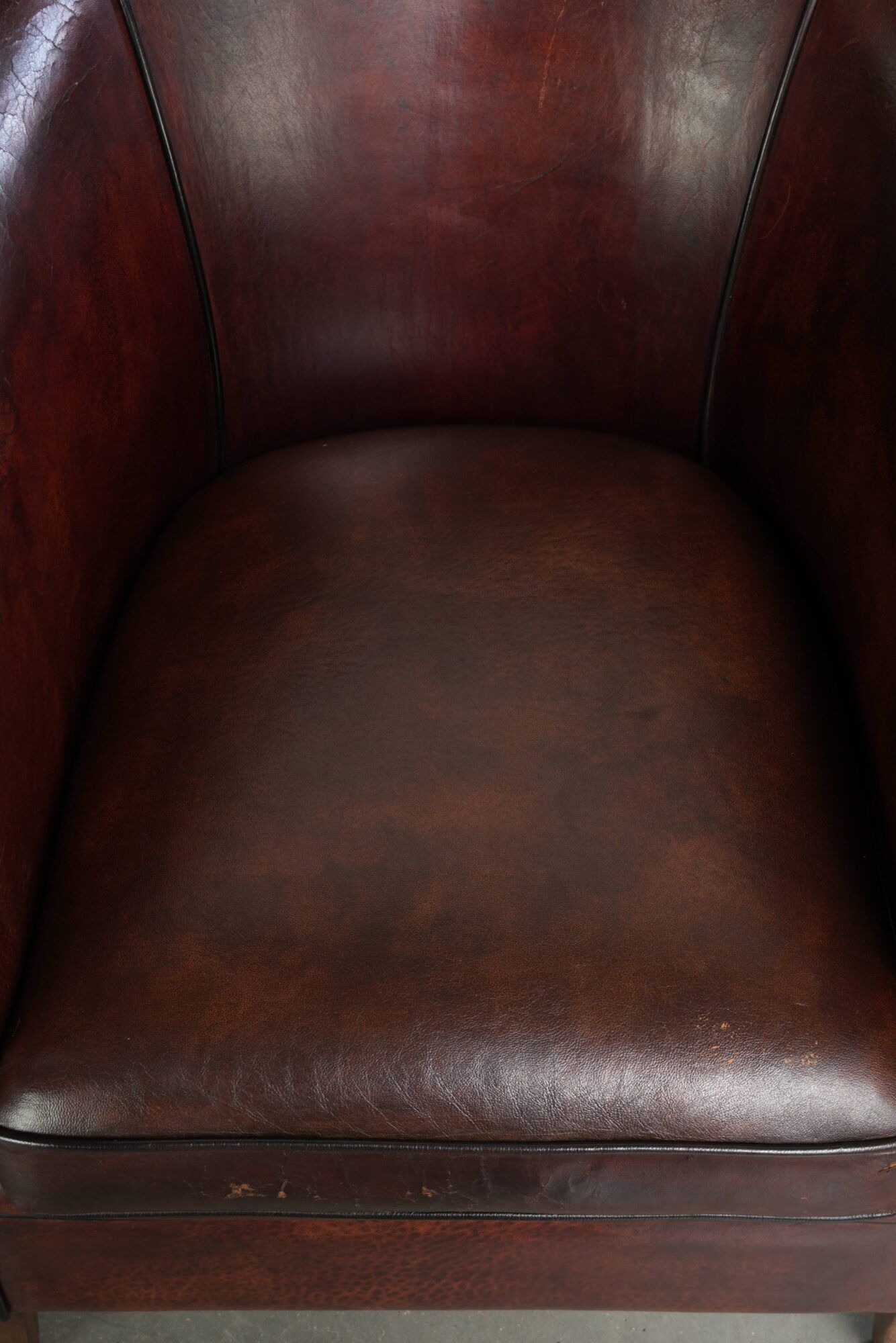 Vintage sheepskin club armchair with decorative nails and black piping