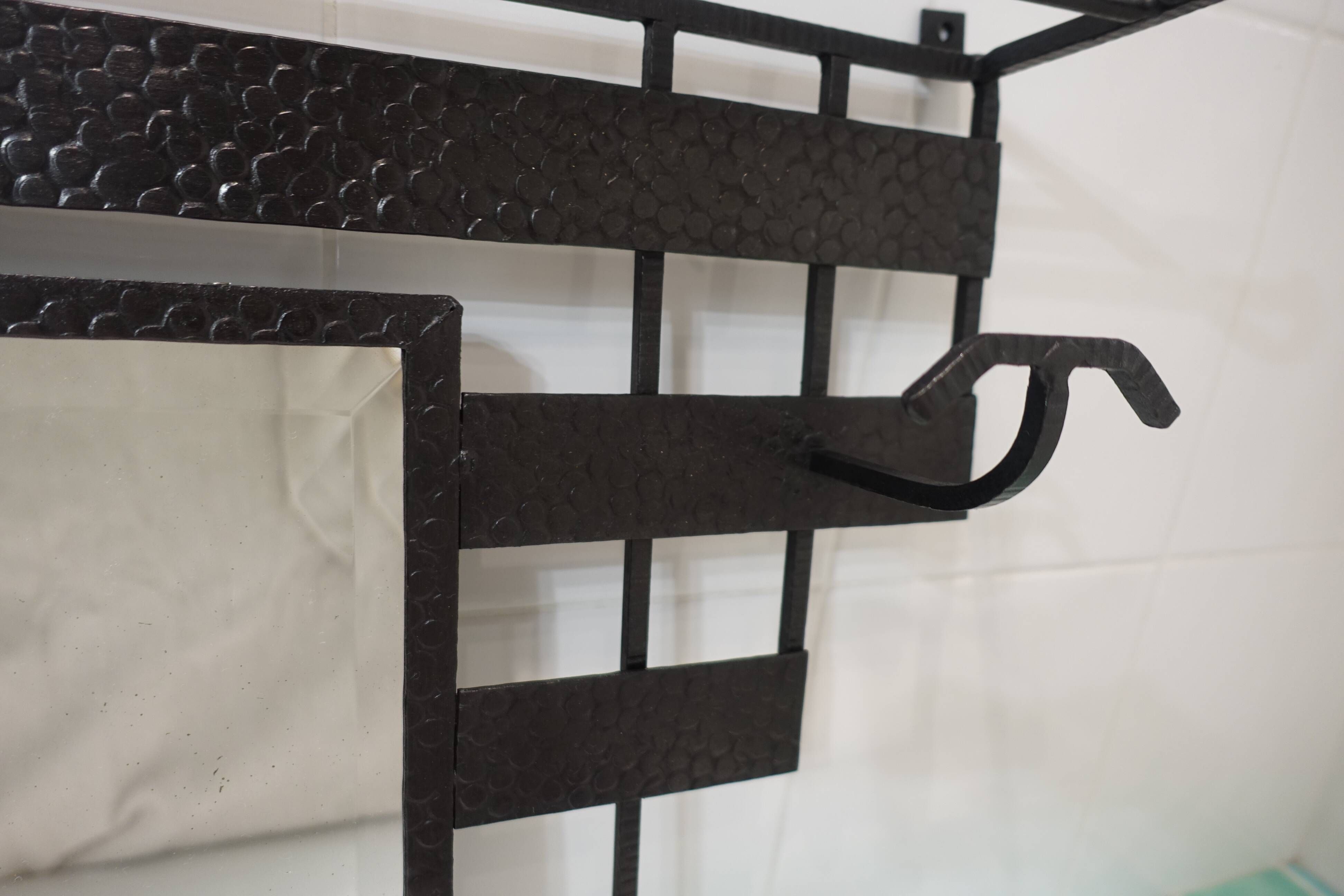 Art Deco wrought iron coat rack with bevelled mirror.