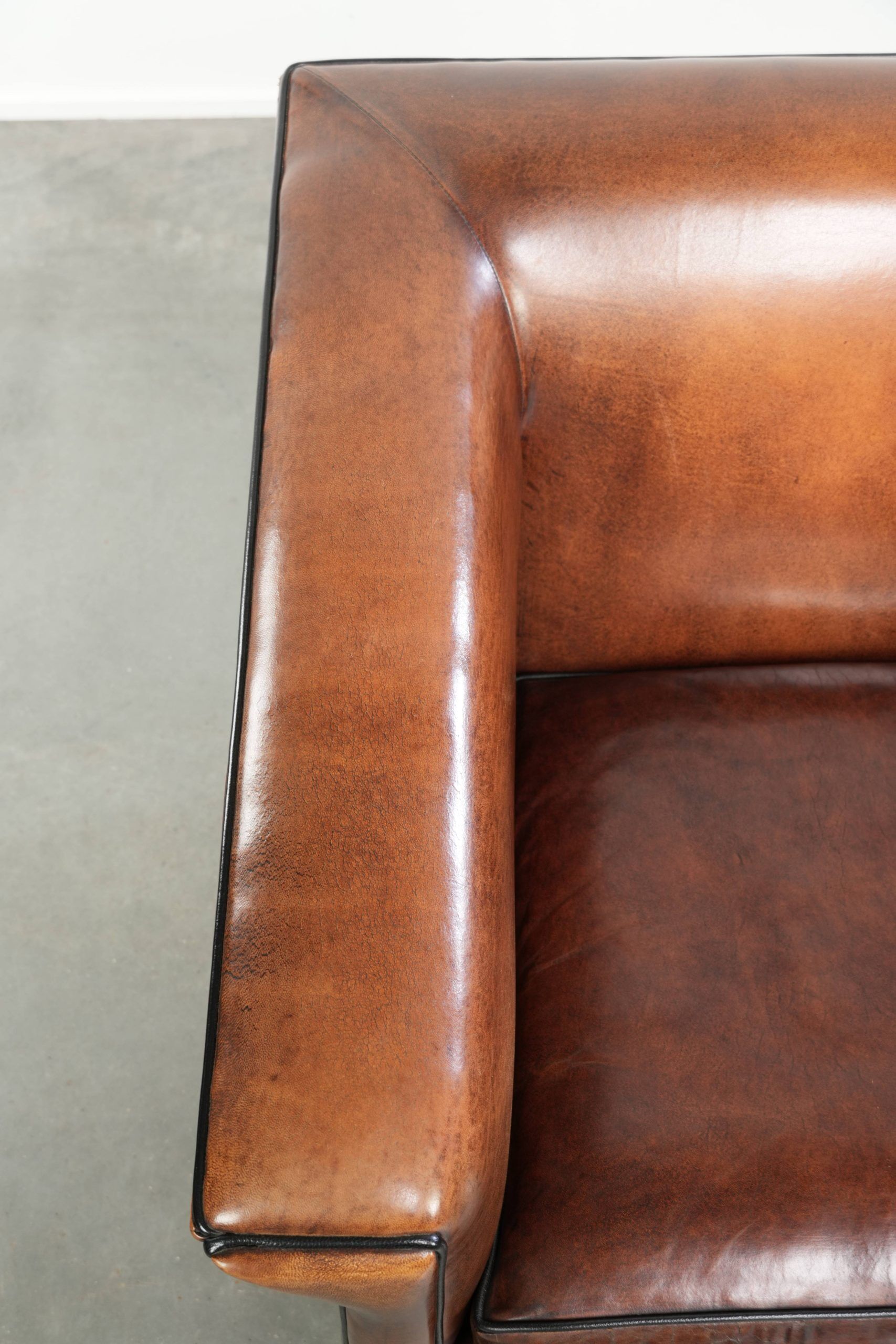 Sleek sheepskin Art Deco design armchair with black piping