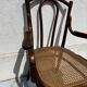 Thonet armchair stamped with curved wooden armrests and caning from the 19th century.