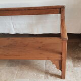 Church bench in fir tree with armrests