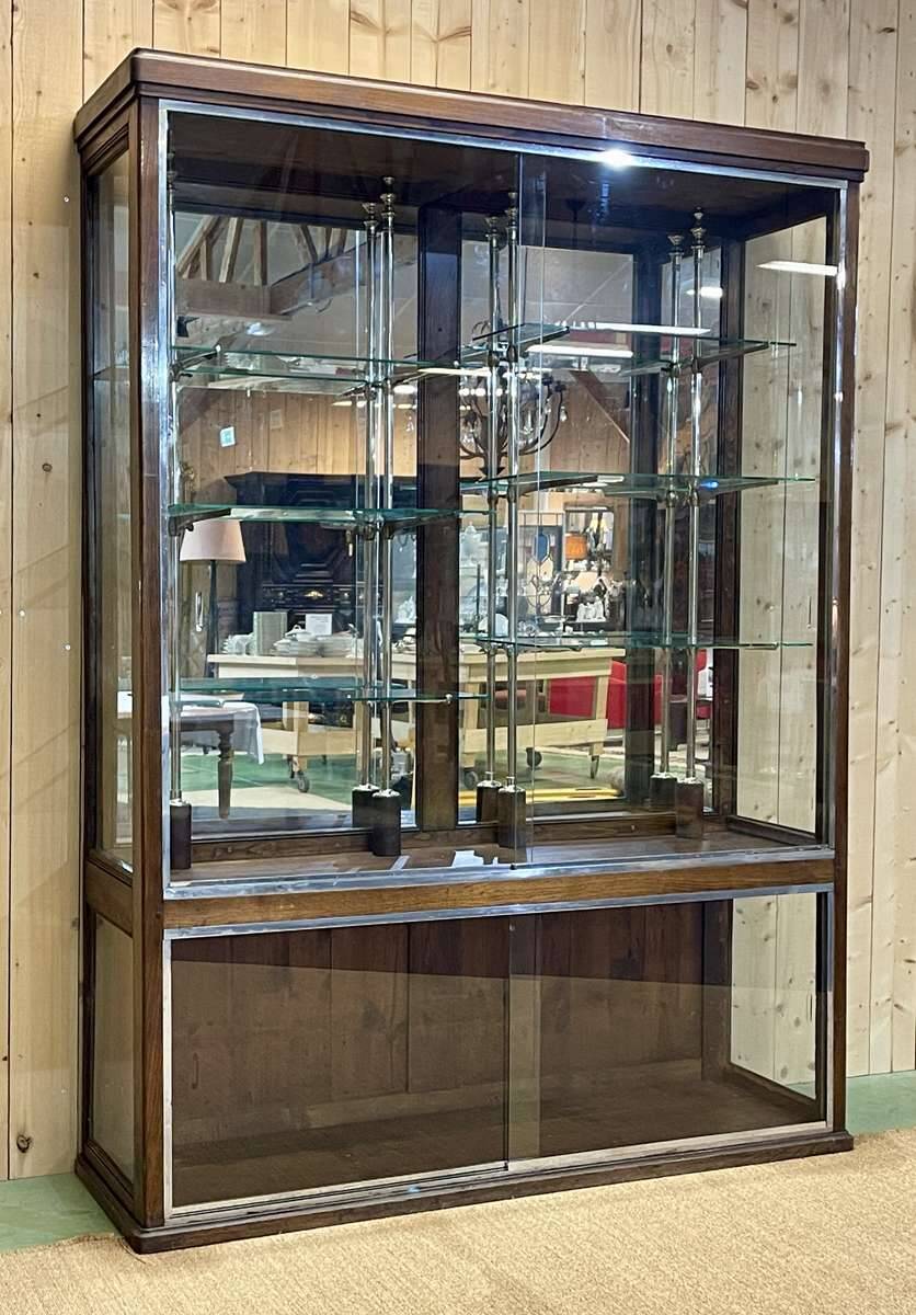 Early 20th-century shop display cabinet in oak with sliding doors.