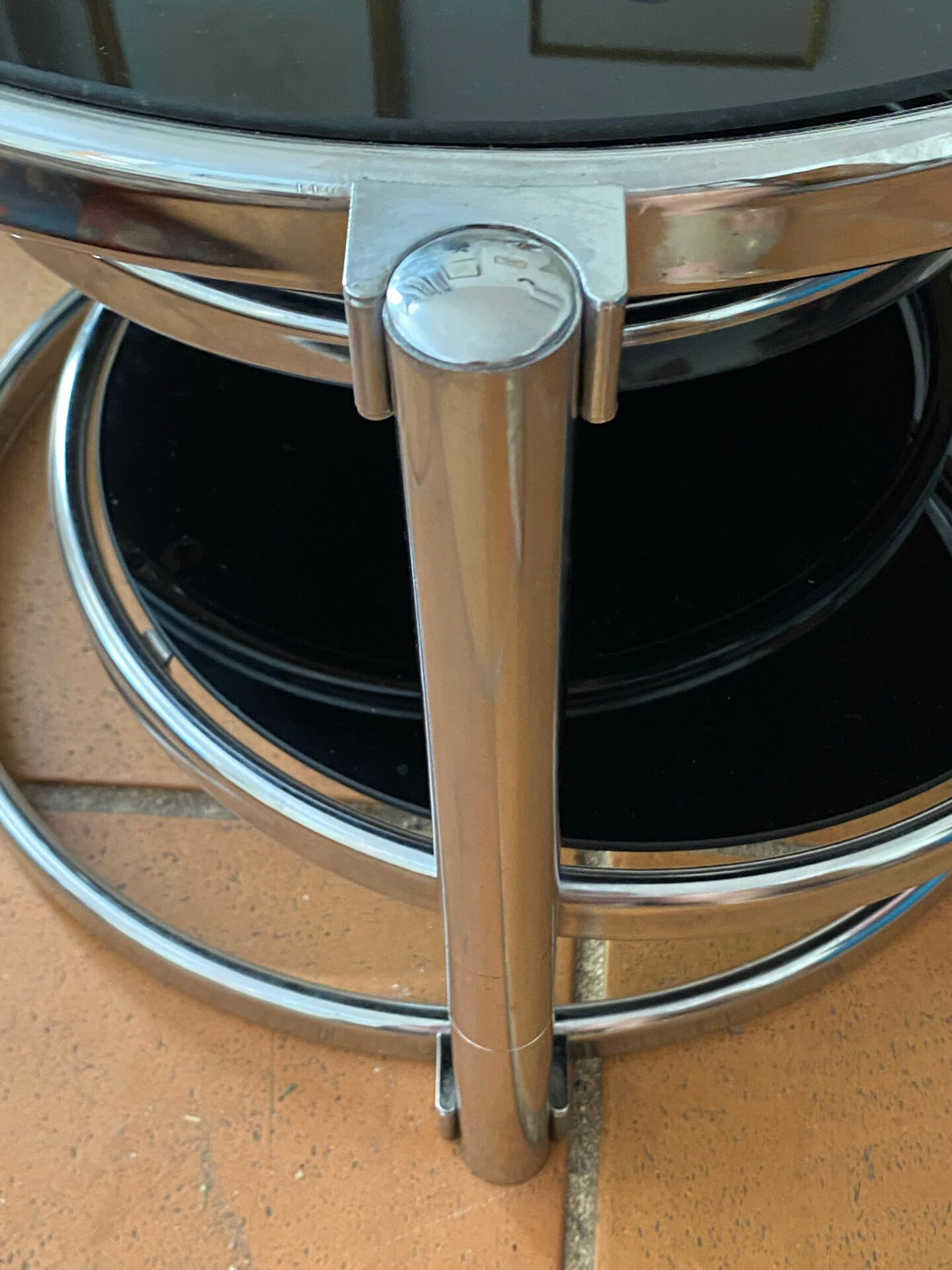 Coffee table with pivoting metal and black glass elements.