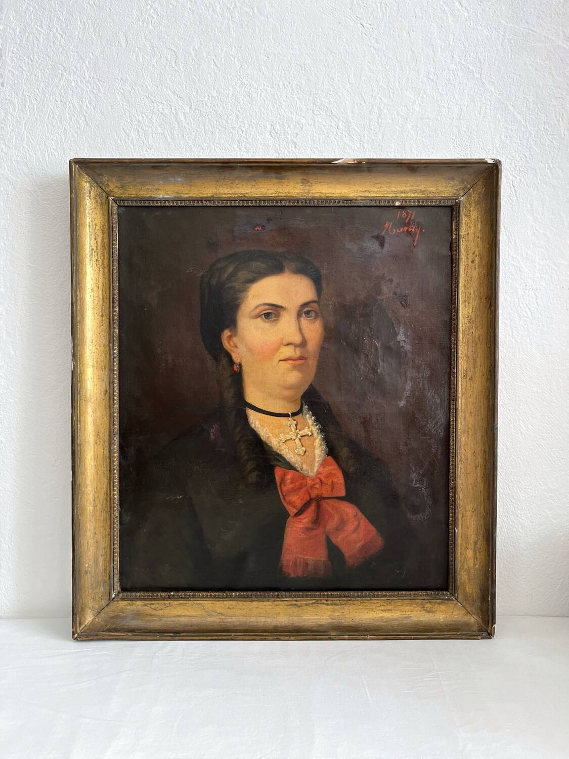 Old oil painting on canvas portrait of a woman with a red bow, late 19th century