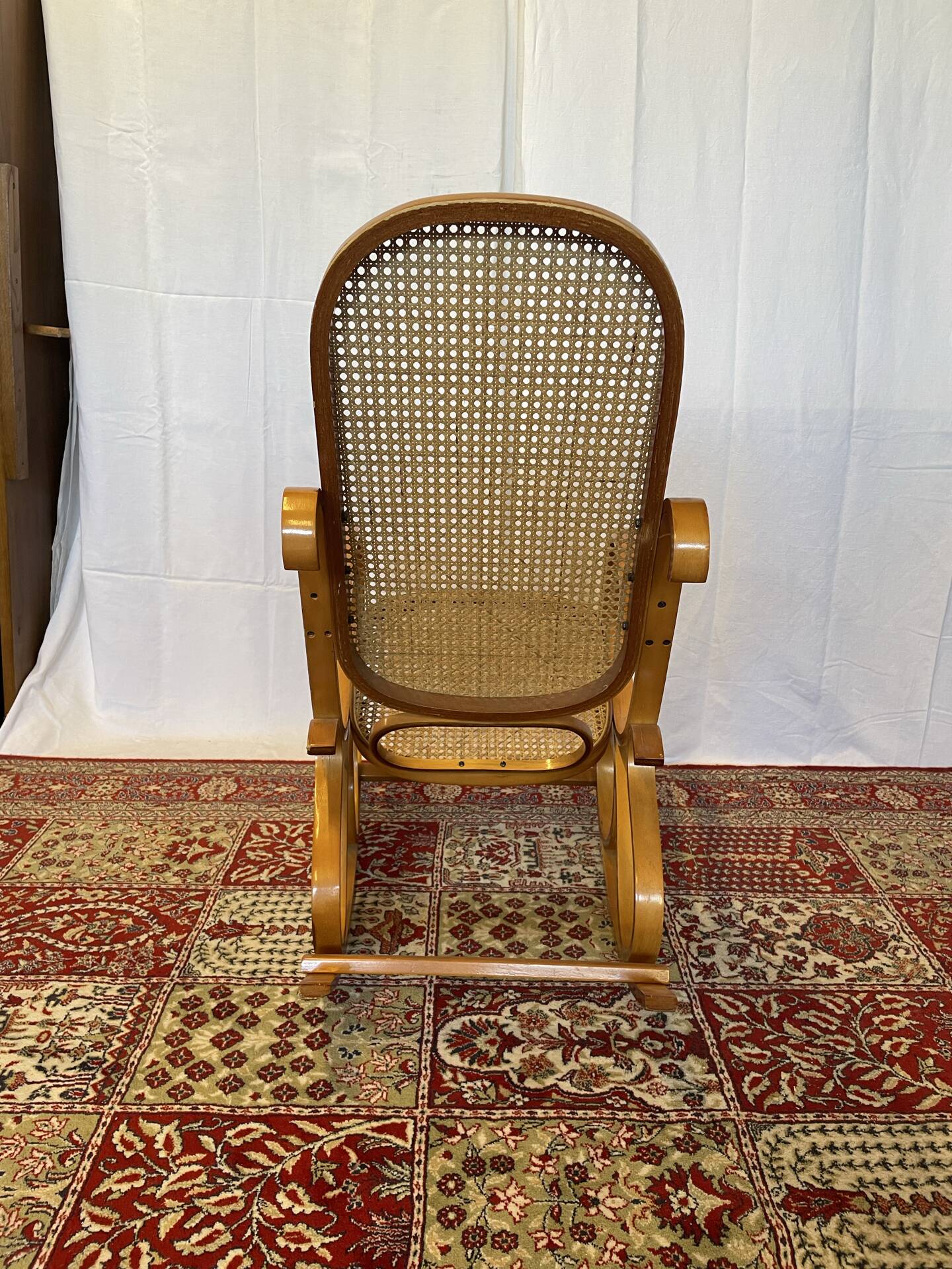 Antique rocking chair in curved wood and caning.