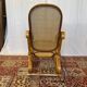 Antique rocking chair in curved wood and caning.