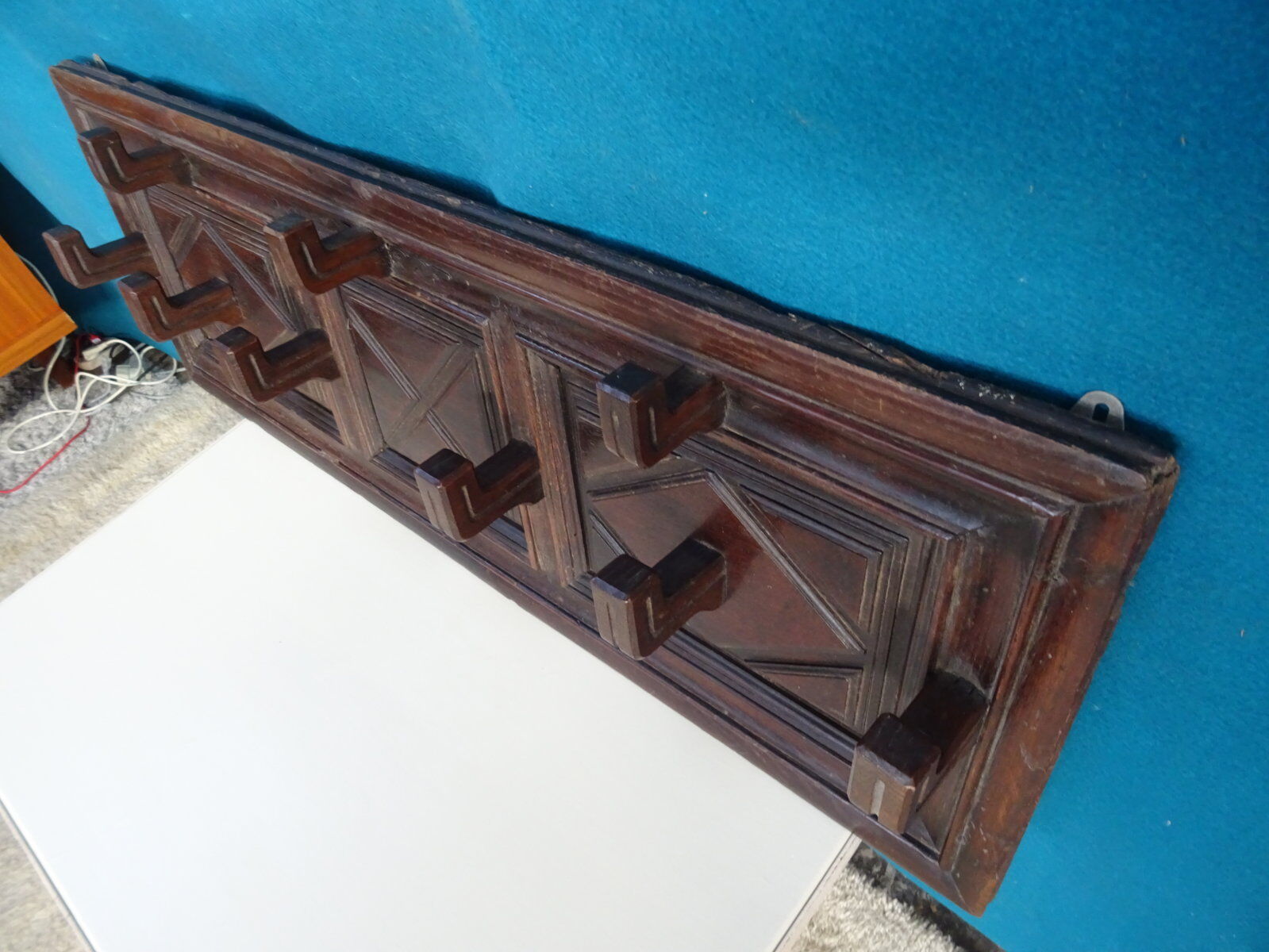 Wall-mounted coat rack in solid oak with 9 hooks.