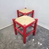Red wooden stool with woven rush seat.