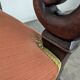Restoration armchair in mahogany with cross arms and orange fabric.