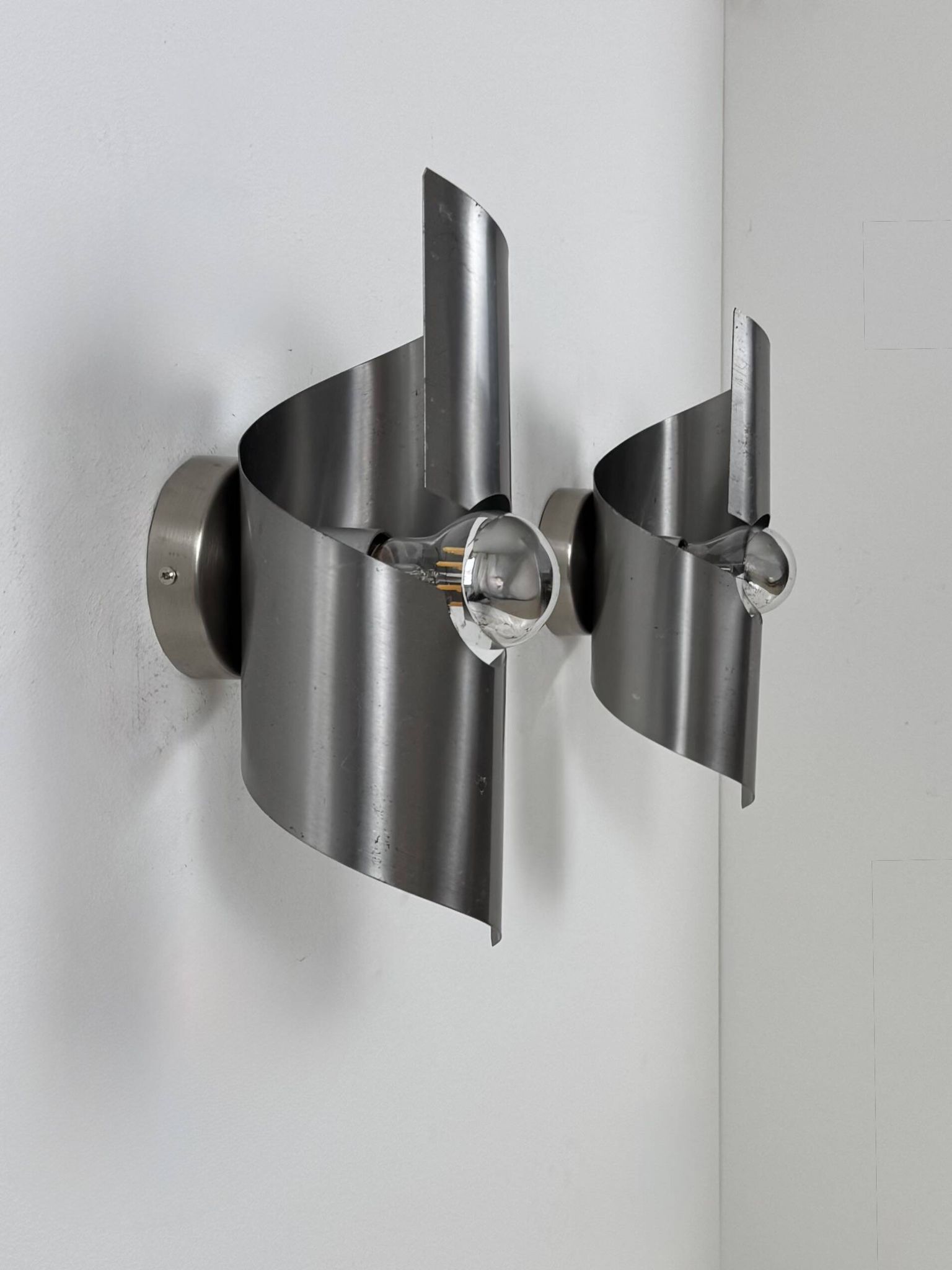 Pair of vintage wall lights, curved patinated steel, France, 1970.