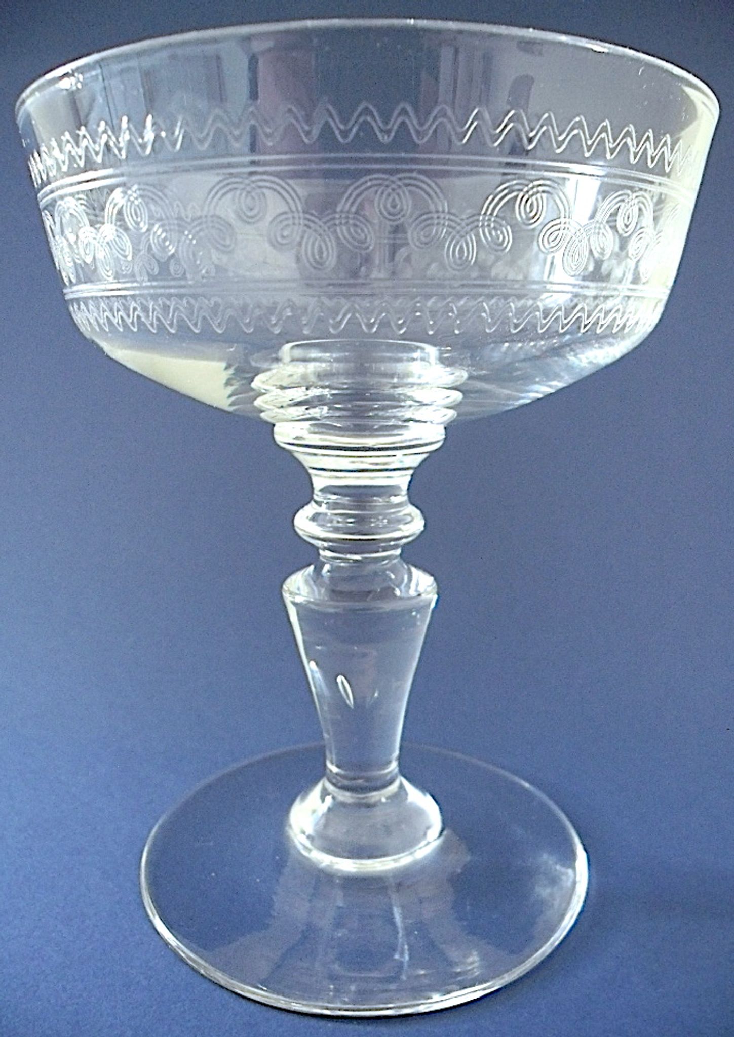 Suite of six champagne glasses on foot in engraved colorless crystal