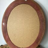 Oval-shaped wooden mirror in gold color
