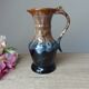 Vintage 1960s brown and blue flame-patterned stoneware wine jug carafe.