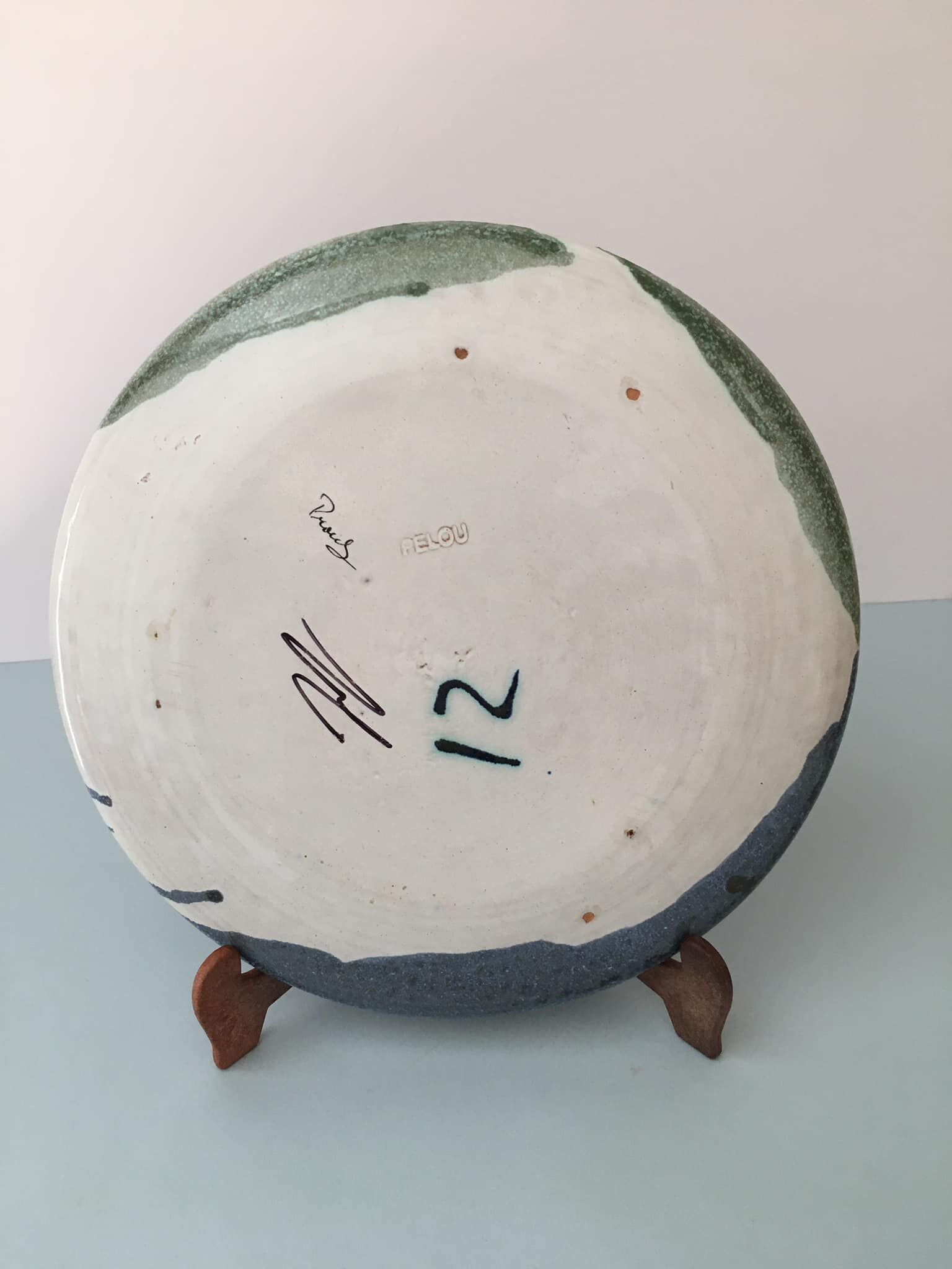 Glazed ceramic plate representation man between two lands unknown signature