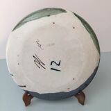 Glazed ceramic plate representation man between two lands unknown signature