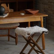 Folding stool, reupholstered in long-haired sheepskin, mid-century modern style, 1950s.