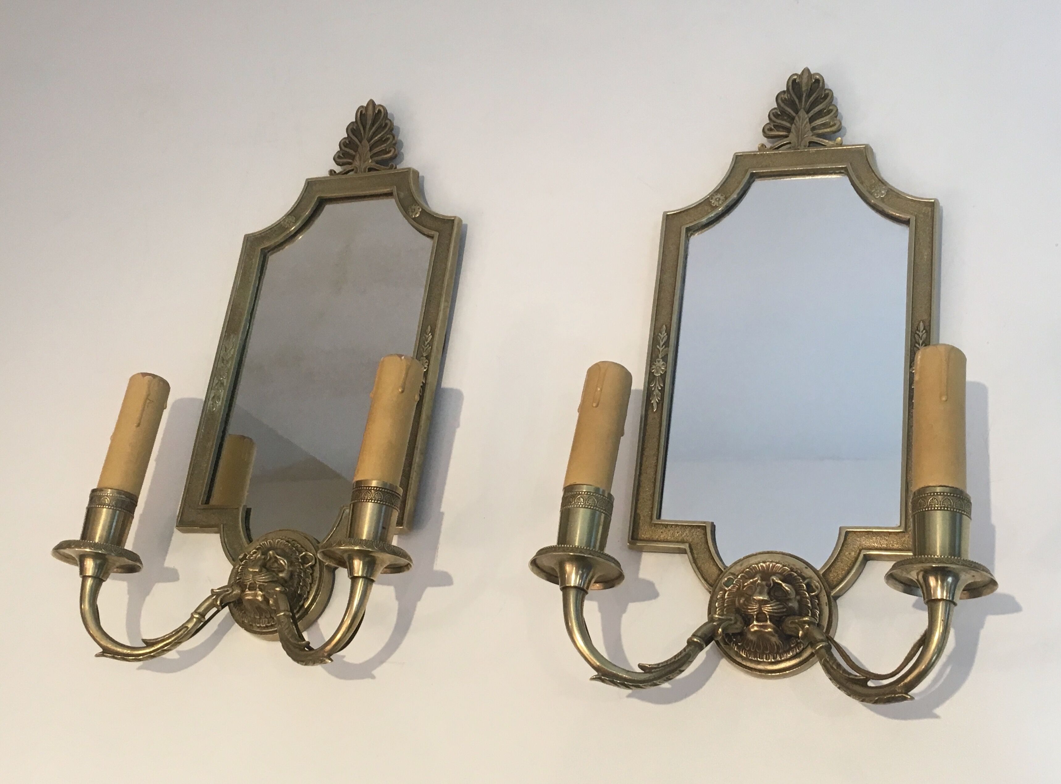 Pair of mirror and bronze wall lamps with lions' heads, french work. around 1940