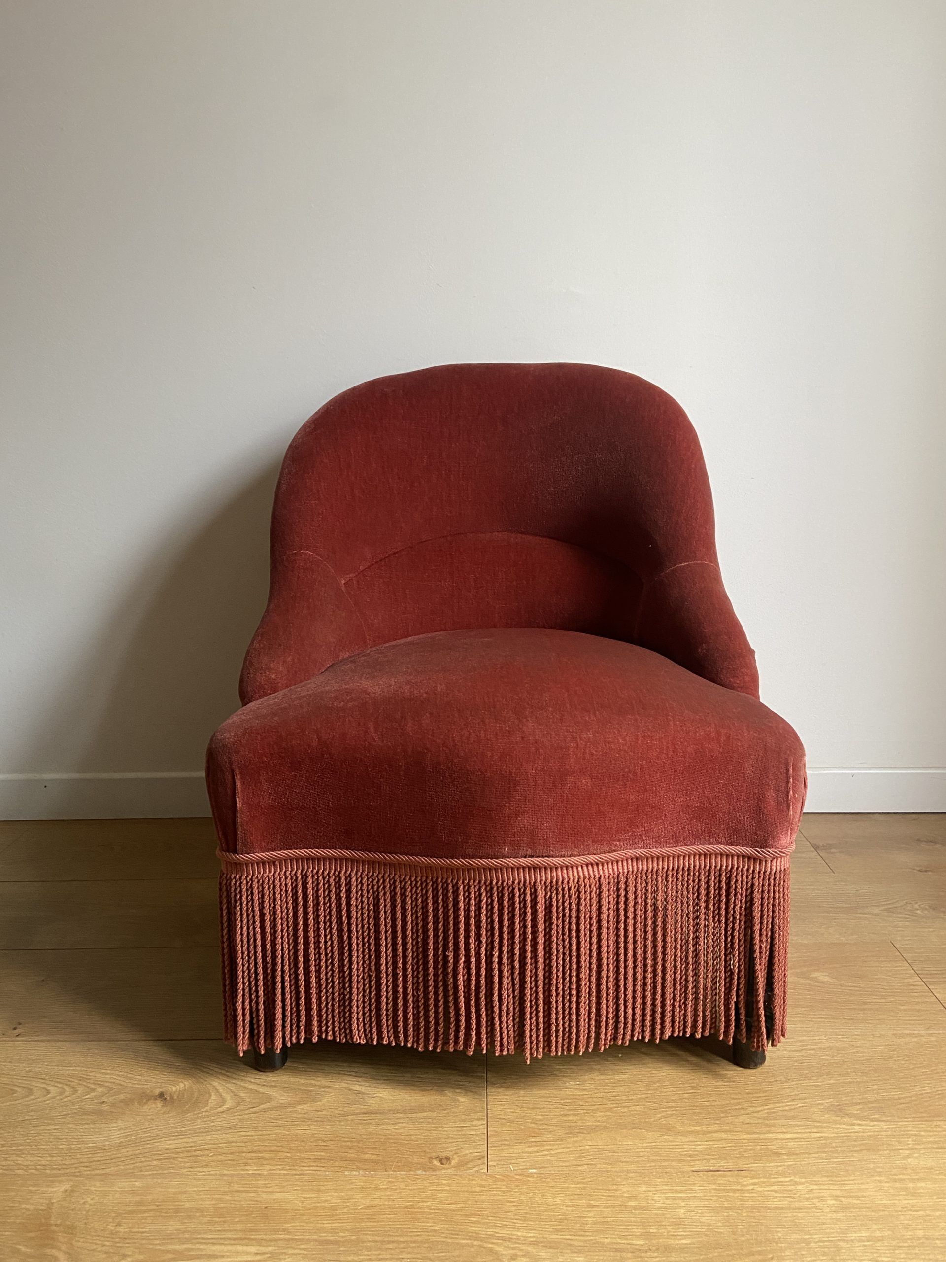 Fauteuil crapaud vintage rose framboise en velours à franges
