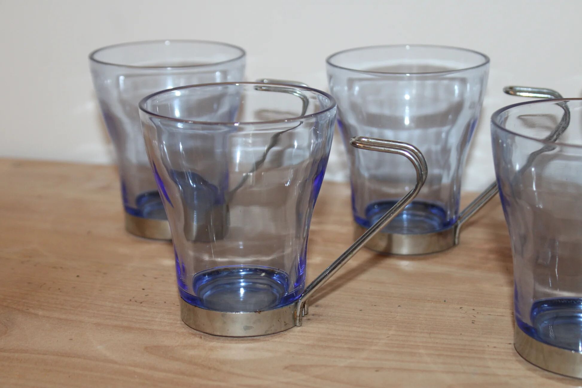 Set of 5 vintage blue-tinted glass cups with metal holders.