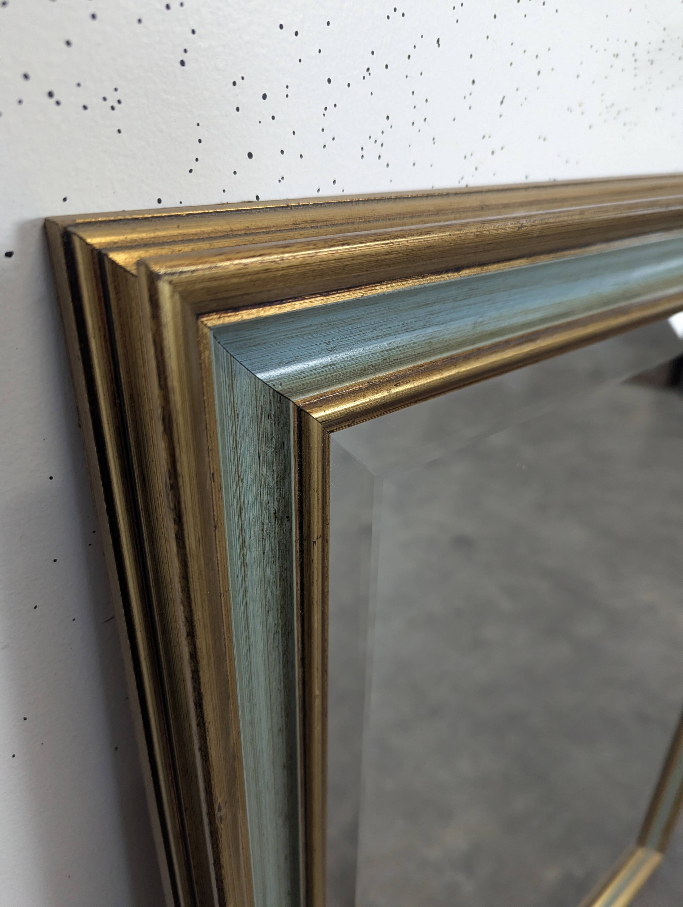 Rectangular mirror with a green and gold lacquered frame.