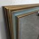 Rectangular mirror with a green and gold lacquered frame.