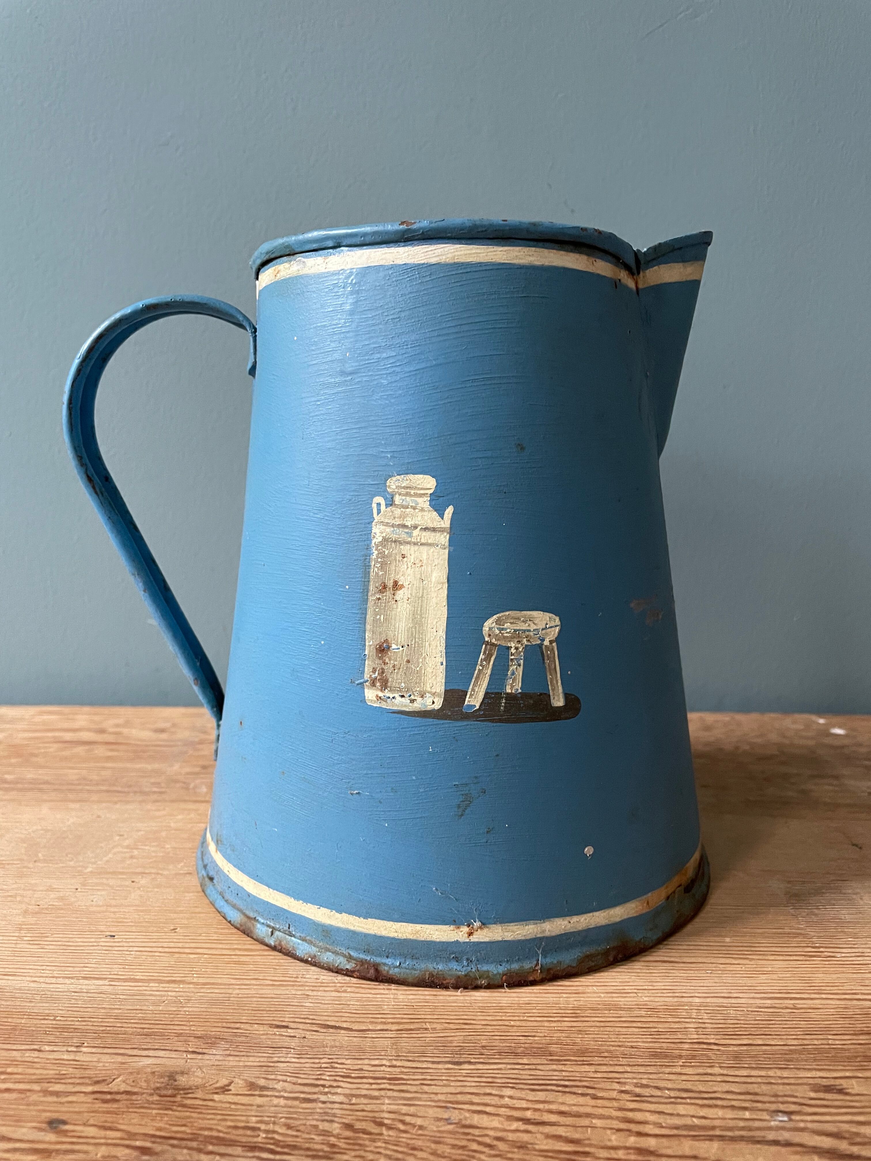 Old painted sheet metal jug or milk jug