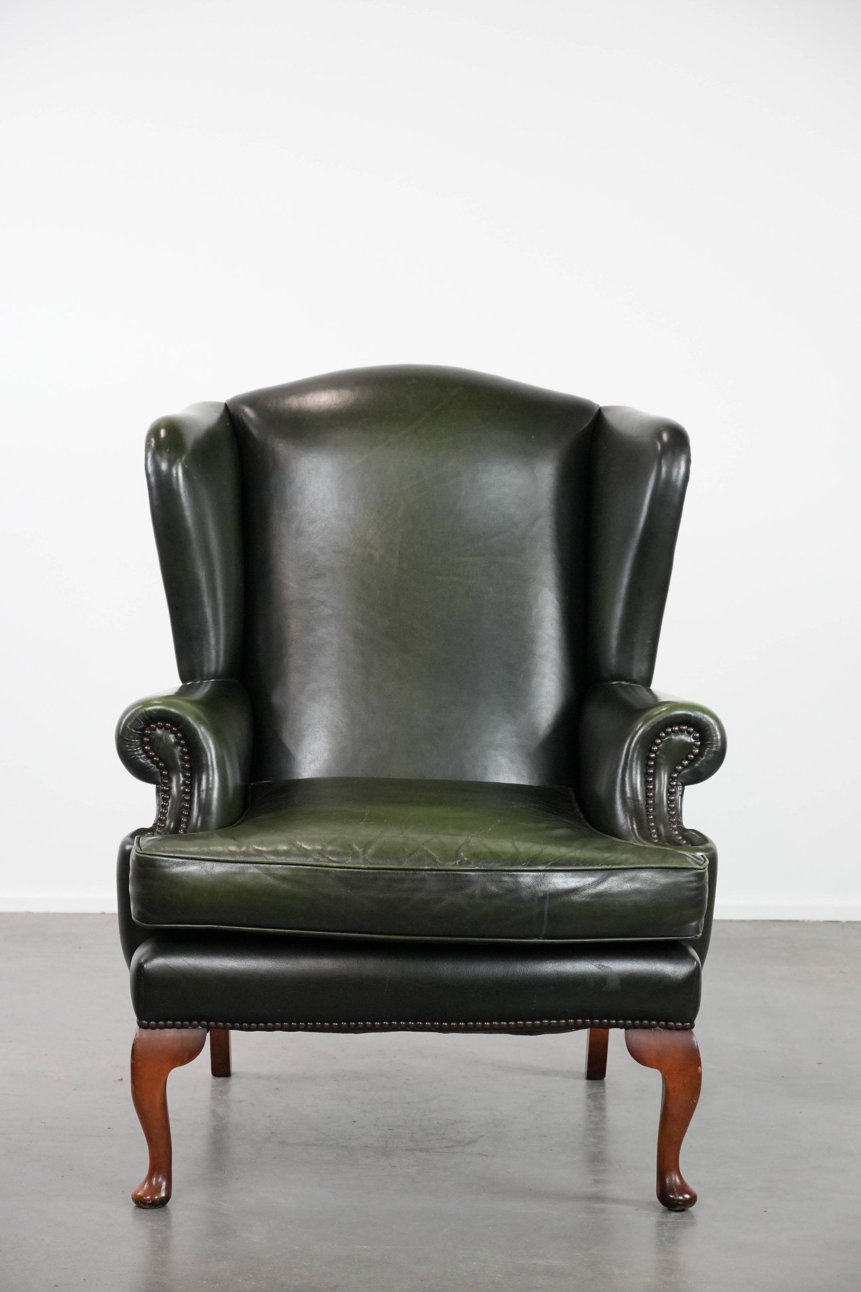 Smooth classic cowhide Chesterfield armchair in a stylish dark green color
