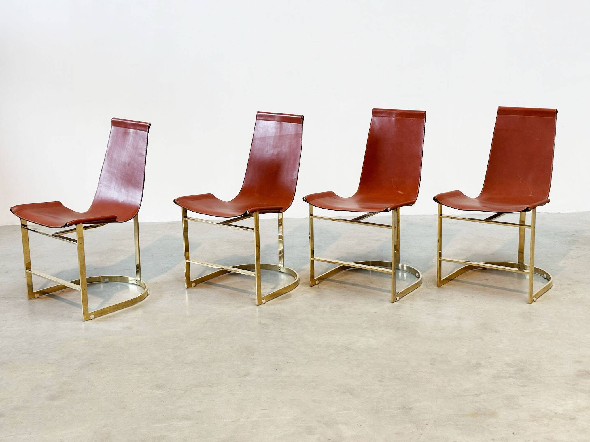 Set of four leather and brass Italian dining chairs