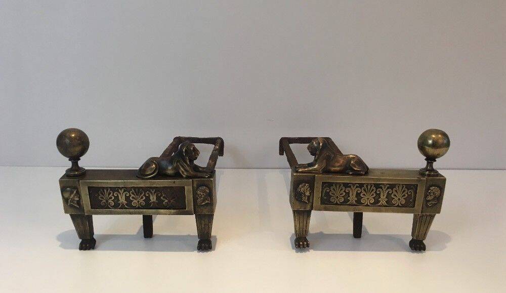 Paire de chenets d'époque Empire en bronze représentant des lions allongés