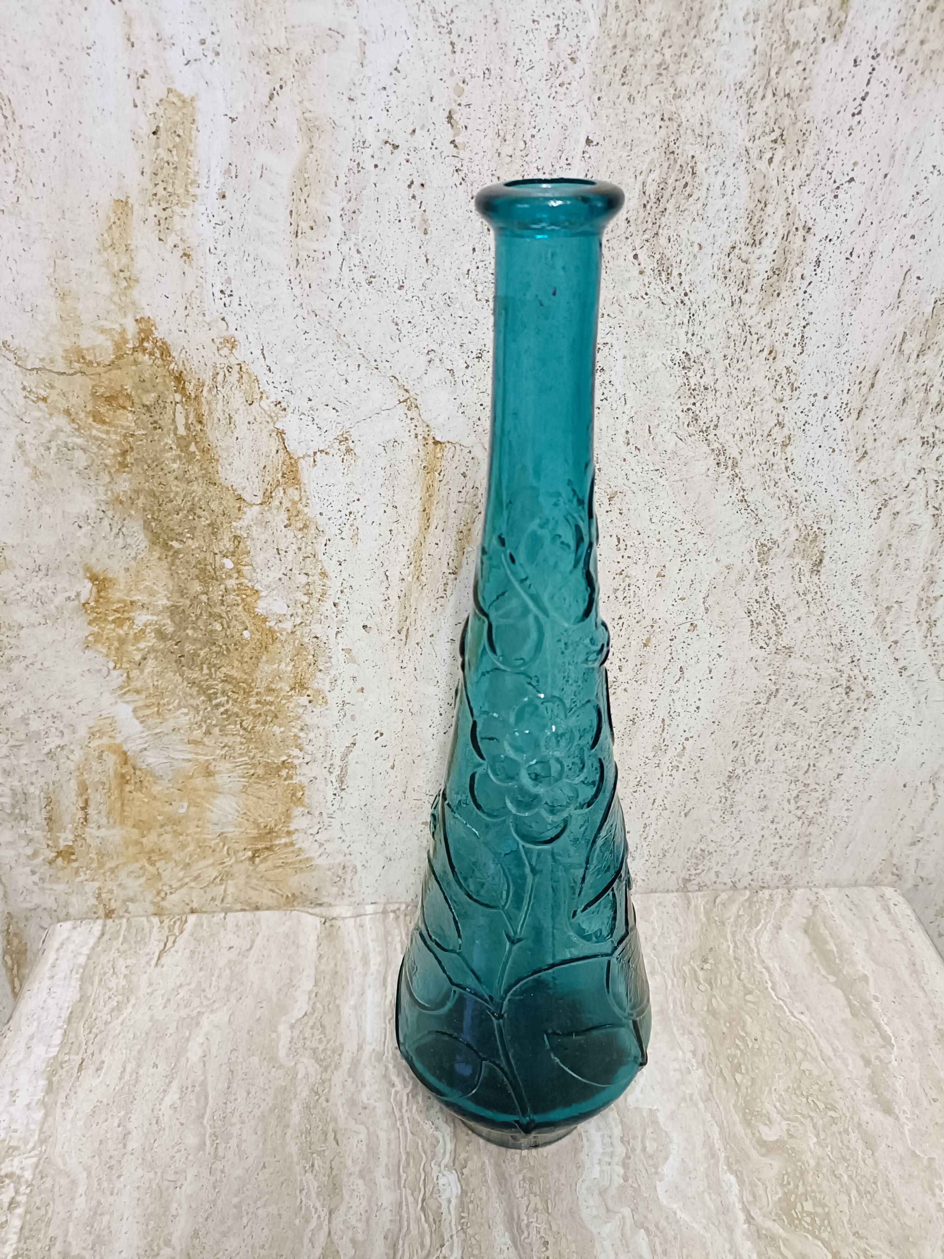 Blue pressed glass bottle decorated with flowers